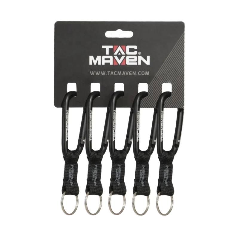 Four black carabiner keychains with black webbing and silver keyrings, attached to a black TAC MAVEN retail card on a white background.