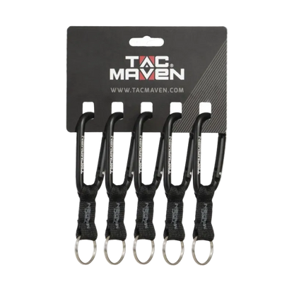 Four black carabiner keychains with black webbing and silver keyrings, attached to a black TAC MAVEN retail card on a white background.